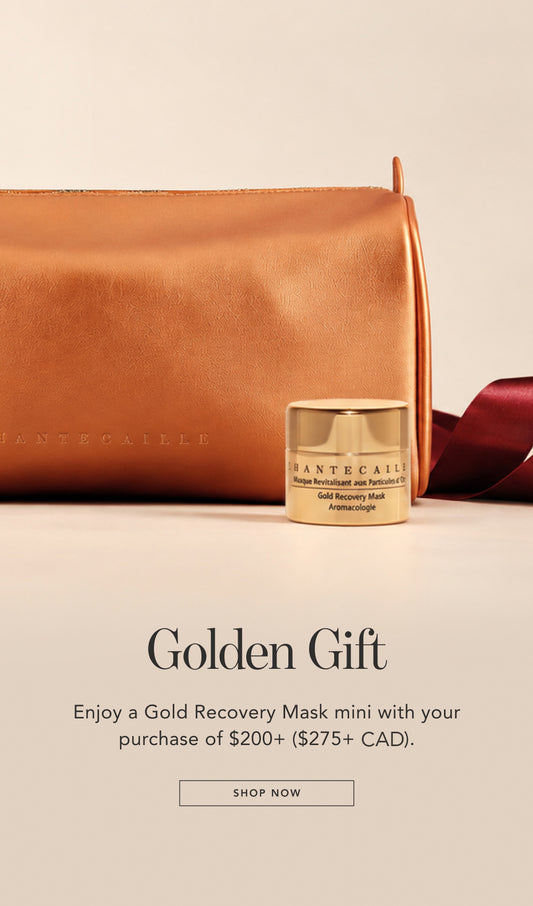 A small gold recovery mask jar sits in front of a tan leather pouch with a dark red ribbon on a light beige background. Text below reads 'Golden Gift' and says the purchase of $200+ ($275 CAD) includes the mini jar.